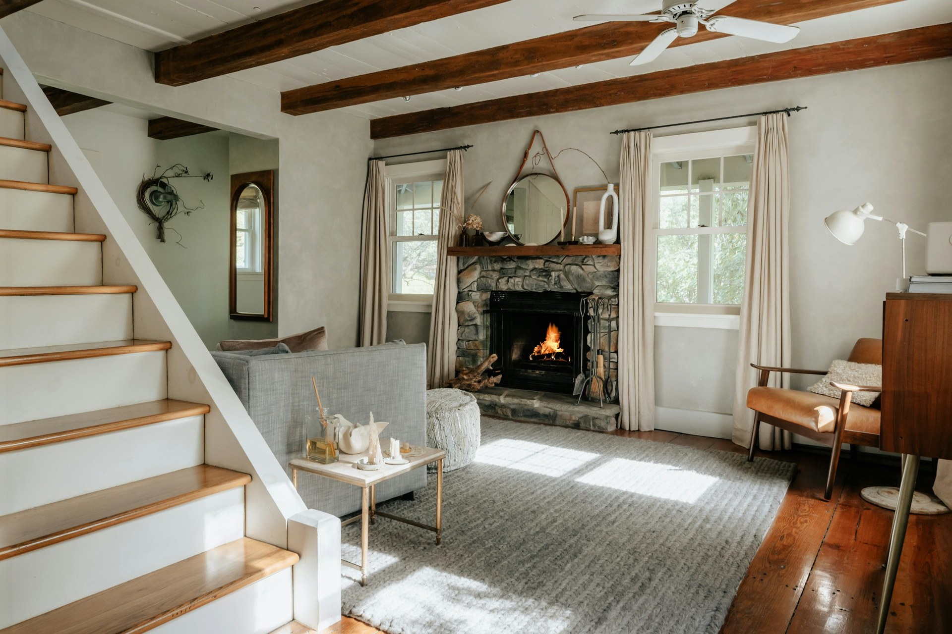Intérieur chaleureux d'un gîte breton, cheminée et poutres apparentes
